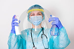 Woman wearing gloves, biohazard protective suit, face shield and mask with hand sanitizer bottle and disinfection gel. corona