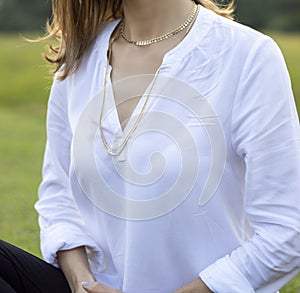 Portrait Woman wearing gold necklace. Necklace at the neck of young woman, women's accessories, gold necklace