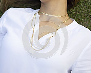 Woman wearing gold necklace. Necklace at the neck of young woman, women's accessories, gold necklace