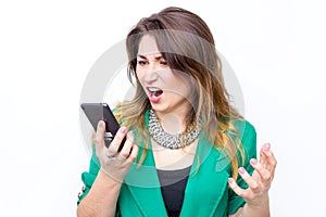 Woman wearing in green jacket shouts in anger to her phone, woman cries in the mobile phone