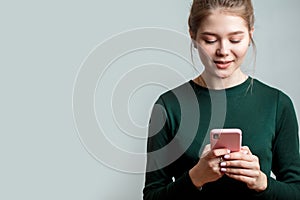 Woman wearing green long-sleeve shirt using a mobile phone isolated on a white