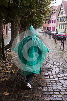 woman wearing a green rain coat poncho in the street