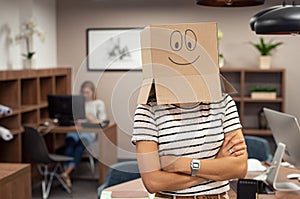 Woman wearing happy face cardboard in office