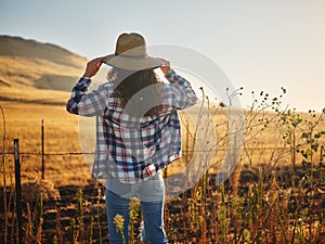 Woman wearing hat from behind looking at view of rural california landscape