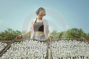 woman wearing headphone standing at thailand local fishing village with smiling face against clear blue sky photo