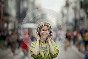 A woman wearing headphones on a crowded street.