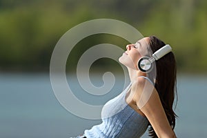Woman wearing headphones listening to music in a lake