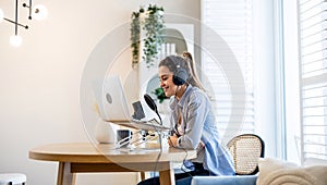 Woman wearing headphones sitting at a desk recording a podcast