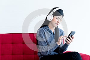 woman wearing headphones  using a mobile phone happily  with white background