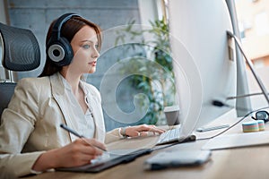 Woman wearing headphones and working in design studio
