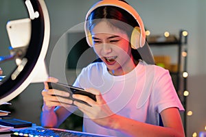 woman wearing headset and playing online game on smartphone with live broadcasting on internet.