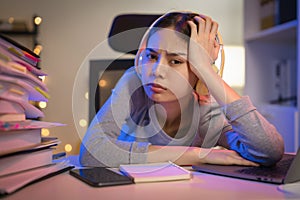 woman wearing headset and sitting on the chair with a pile of papers document on the table and looking on the computer screen