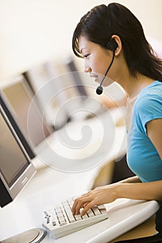 Woman wearing headset sitting in computer room