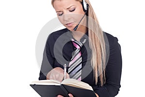 Woman wearing a headset taking notes