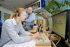 woman wearing headset and typing in control center