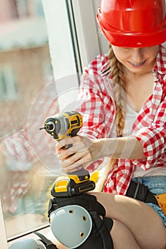 Woman wearing helmet using drill