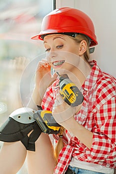 Woman wearing helmet using drill