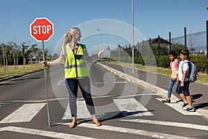 Woman wearing a high visibility vest and holding a stop sign