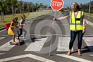 Woman wearing a high visibility vest and holding a stop sign