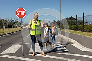 Woman wearing a high visibility vest and holding a stop sign