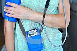 Woman wearing holter monitor device for daily monitoring of an electrocardiogram.