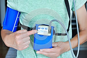 Woman wearing holter monitor device for daily monitoring of an electrocardiogram.