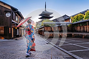 Woman wearing japanese traditional kimono with umbrella at Yasaka Pagoda and Sannen Zaka Street in Kyoto, Japan photo