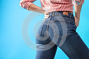 Woman wearing jeans on blue, closeup