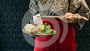 A woman wearing kimono holding cabbage over Sukiyaki vegetables set including cabbage, false pak choi, carrot, shiitake, enokitake