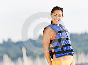 Woman wearing life jacket at beach photo
