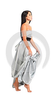 Woman wearing long silver dress goes on tiptoe