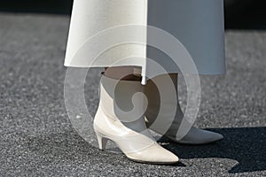 Woman wearing a long white dress and leather white shoes
