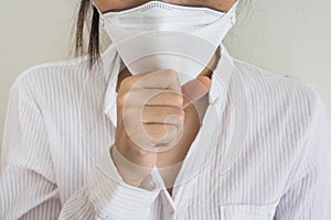 A woman wearing a mask is doing a sore throat