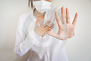 A woman wearing a mask is doing a sore throat