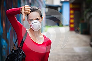 Woman wearing mask doing thumbs down