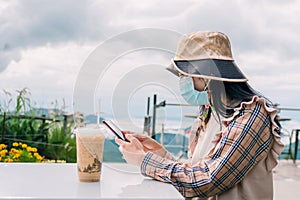 Woman wearing a mask while drinking coffee while traveling