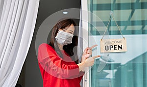 Woman wearing mask opening store with sign board front door shop for service customer, Small business
