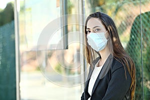 Woman wearing a mask to prevent contagion in a bus stop photo