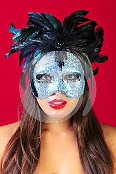 Woman wearing a masquerade mask red background