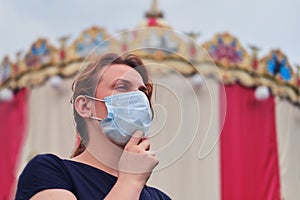 A woman is wearing a medical mask before holding public holidays. Safety of public events under quarantine due to flu virus