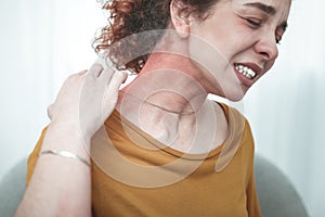 Woman wearing orange shirt having rash and reddening on neck