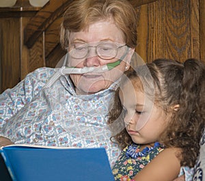 Woman wearing oxygen reads to child