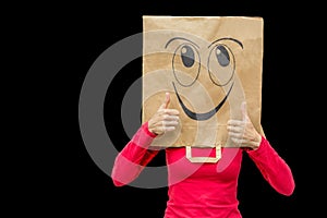 Woman wearing paper bag with happy face on black