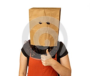 Woman wearing paper bag over her head giving thumbs up with left hand