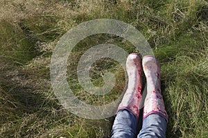 Woman Wearing Pink Galoshes Lying On Grass