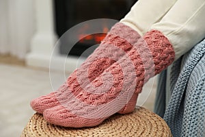 Woman wearing pink warm socks near fireplace, closeup