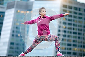 Woman wearing pink in Warrior 2 pose