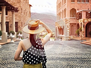 Woman wearing a planter panama hat visiting an Italian style village in summer
