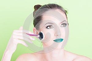 Woman wearing professional make-up holding brush