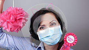 Woman wearing protection face mask against coronavirus. Woman in a mask with party supply. Happy birthday girl with cat ear